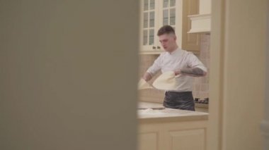 Ağır çekim iplik ve pizza hamur evde mutfakta iki disk savurma biri. Profesyonel oyuncu pizza yapma. Yiyecek hazırlama kavramı.