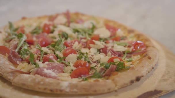 Közeli kép: étvágygerjesztő ízletes olasz pizza feküdt egy fából készült hajón. — Stock videók