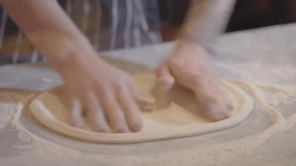Närbild av händerna på unga pizzabagare i förkläde förbereder degen. Kocken gör pizza — Stockvideo