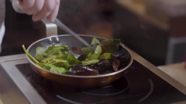 Midye Tava yağı ve sarımsak maşa kullanarak tıslama üzerinde yaprakları ile karıştırma Şef eller kapatın. Hazırlık deniz ürünleri Restoran mutfak at