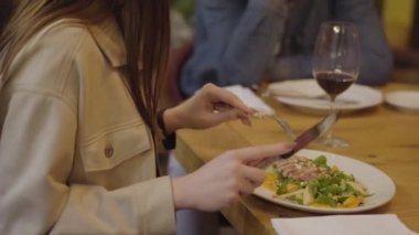 Yemek ve şarap içme modern kafede tanınmaz çift. Kadın yemek salata etli kapatın. Erkek ve kadın bir restoranda randevum. Kamera hareketleri doğru