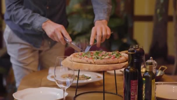 알 수 없는 남자 칼과 포크를 사용 하 여 식당에서 테이블에 맛 있는 피자를 잘라냅니다. 절묘 한 음식에 비싼, 호감 레스토랑. — 비디오