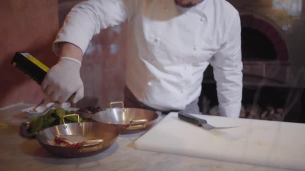 Chef-kok olei giet op een heerlijke schotel van vis- en groentenconserven liggend op een bakplaat en zet het in de oven. — Stockvideo