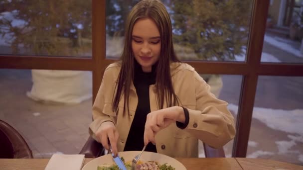 Retrato de una linda chica cenando en un restaurante. Lady disfruta comiendo un delicioso plato de verduras frescas y mariscos . — Vídeo de stock