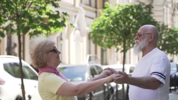 Gyönyörű idősebb pár tánc waltz a városi utcán — Stock videók