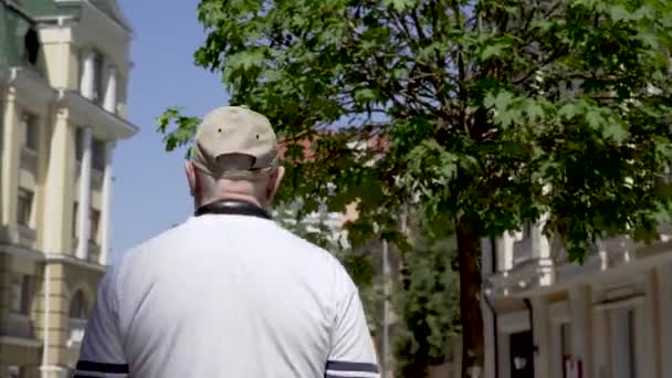 Senior mannen promenad i staden och ta foton — Stockvideo