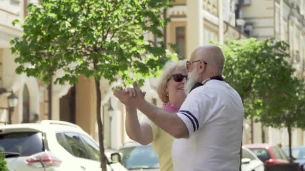 Старшая пара наслаждается друг другом и танцует вальс на городской улице — стоковое видео