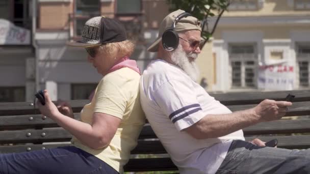 Стильная зрелая пара отдыхает на скамейке в городе — стоковое видео