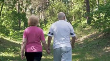 Üst düzey kadın kocasıyla yaz parkta yürüyüş