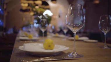 Pahalı bir restoran bir tabloda hizmet. Boş şarap gözlük, beyaz tabak, çatal bıçak takımı ahşap bir masa üzerinde. Sulu limon yalan plakaları.