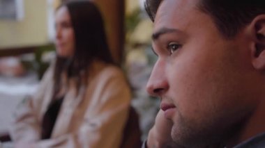 Pencerenin oturan modern kafede yemek iki arkadaş. Yüz üzgün adam yakın çekim.