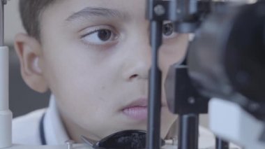Göz testi yaptıkları Afro-Amerikan çocuk göz test makinesini göz doktoruna tıbbi ofis içinde bakarak göz doktoru ile yakın çekim. Tıp, sağlık, Oftalmoloji kavramı