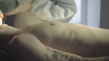 Doktor beyaz paltolu bir adam için oksijen maskesi pompalama. Akciğer havalandırma.