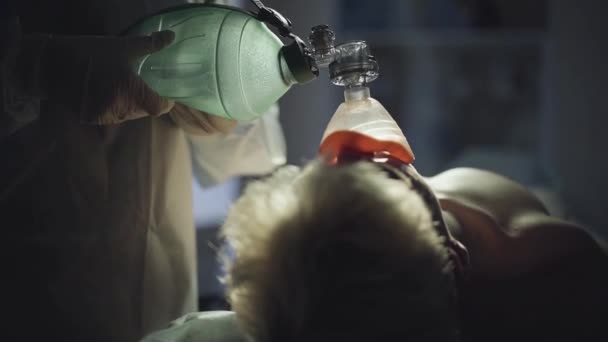 Doktorlar eller beyaz paltolu bir adam için oksijen maskesi pompalama. Yakın çekim. — Stok video