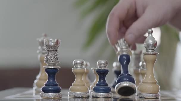 Hand van de mens is vastgelegd van een schaakstuk. Twee mannen handen schudden over een schaakbord. De prachtige Schaken instellen met zilveren inzetstukken permanent op schaakbord close-up. Deal bedrijfsconcept — Stockvideo