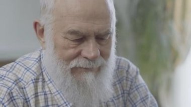 Evde oturan düşünceli sakallı olgun adam portresi kapatın. Komuta sizde rahatsız hissediyor. Yaşlı adamın bir sorunu var