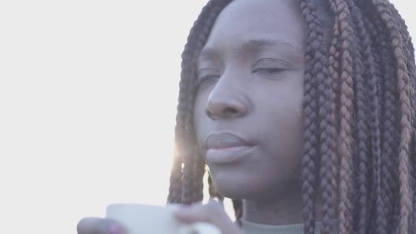 Close up retrato de confiante afro-americana jovem negra sorrindo mulher com xícara de café quente na rua. Movimento lento — Vídeo de Stock
