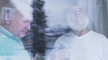 İki yaşlı adam alkol viski ayakta pencerenin evde içme. Beyaz yaşlı adamlar kapalı birlikte vaktinizi arkadaşlar komşular. Emekliler eğlence. Cam arkasından çekim