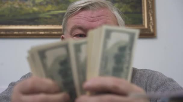 Handen van de oude man tellen dollar close-up. Positieve rijke man toont zijn geld. Vrije tijd van welvarende gepensioneerde man. Grote zakelijke deal — Stockvideo