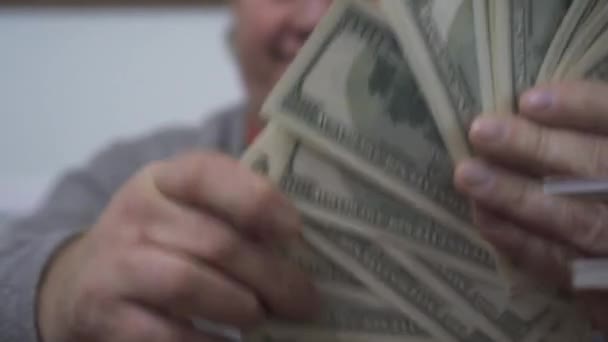 Les mains du vieil homme comptant les dollars se rapprochent. L'homme riche positif démontre son argent. Loisirs d'un retraité prospère. Grande affaire — Video