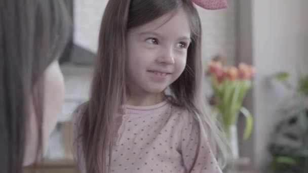 Tres generaciones de mujeres felices sentadas juntas y jugando con una niña traviesa . — Vídeo de stock