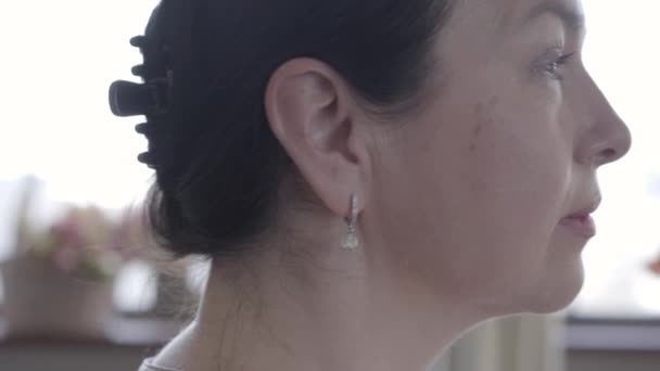 Retrato de perfil de una anciana confiada mirando hacia otro lado. Retrato interior de una mujer jubilada sonriente. Rostro cercano de la anciana dentro de la casa — Vídeo de stock