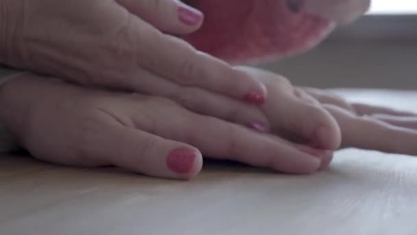 Primo piano di mani di donna matura più anziana e bambina. La nonna passa del tempo con la nipote, si tengono per mano. Concetto di generazione, amore, famiglia — Video Stock