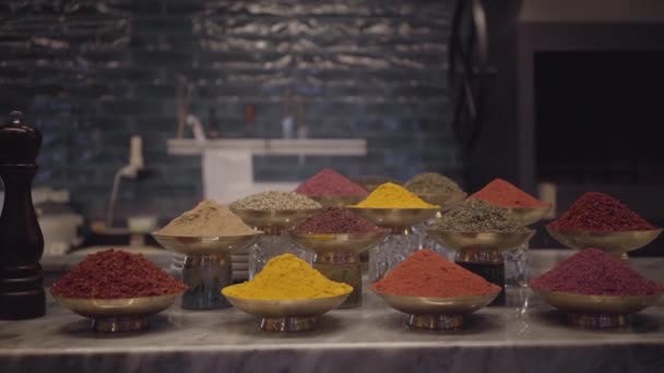 Différents types d'assaisonnements sur le comptoir du magasin dans des bols en métal. Variété d'épices et d'herbes sur la table attendant le client . — Video