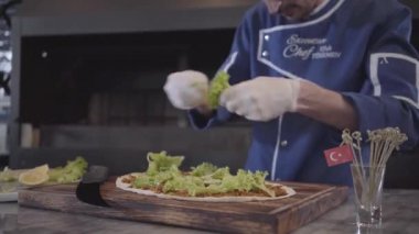Lezzetli yemek hazırlama aşçı üniformalı usta erkeklere lavaş içinde sarılı. Şef el beyaz kauçuk eldiven gözyaşları marul yaprakları ve pide üzerinde yerleştirmektedir. Türk mutfağı