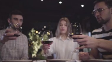 İki erkek ve kadın modern Türk restoranında masada oturan kırmızı şarap ile onların makara tungur. Arkadaşları birlikte rahatlatıcı toplantı, hakkına sahiptir.
