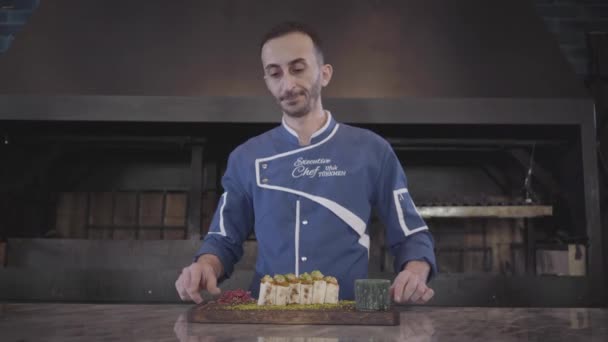 Porträtt av kocken visar bara färdiga välsmakande maträtt i moderna Turkiet restaurang närbild. Mannen i kock uniform föreslår kebab insvept i lavash pita. Turkisk mat — Stockvideo