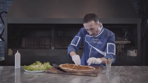 Un chef expérimenté en uniforme blanc prépare un délicieux khachapuri. Cuire met la farce dans la pâte . — Video
