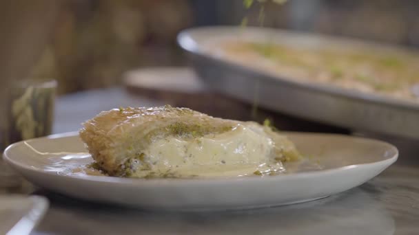 Prato doce oriental kunafa com queijo polvilhado com pistácios na mesa de perto. Preparação de comida em restaurante. Cozinha turca — Vídeo de Stock