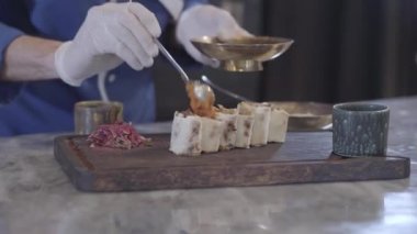 Modern restoranda lezzetli yemek pişirme Şef kapatın. Eller bir adam aşçı üniforma ve lastik eldiven kesilerek lula kebabı lavaş pide tepesi koyarak rulo. Türk mutfağı
