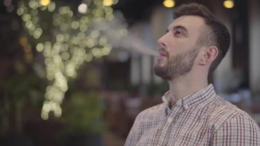 Yakışıklı adam modern restoran veya Cafe nargile keyfi portresi. Yakışıklı adam rahat rahatlatıcı