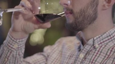 Yarım yüz şarap içme sakallı bir adam portresi yakın çekim.