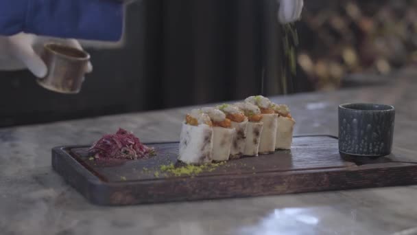 Chef cucina gustoso piatto in ristorante moderno da vicino. Uomo spruzzando lula kebab in rotoli di pita lavash con condimento guardando attentamente il cibo. Cucina turca — Video Stock