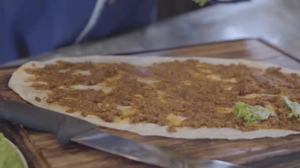Τα χέρια του ανθρώπου στη λαστιχένια γάντια προετοιμασία πιάτο τυλιγμένο σε πίτας. Σεφ χέρι προσεκτικά εξαπλώνεται καλύμματα πάνω από την πίτα. Τουρκική κουζίνα — Αρχείο Βίντεο