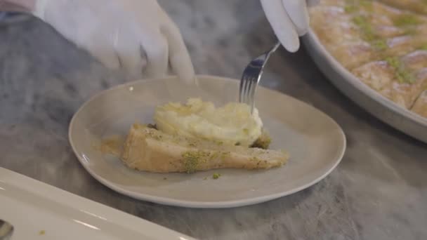 Handen van chef-kok in witte rubberen handschoenen Oost-zoete kunafa ophangen van gesmolten kaas binnen sluiten van voorbereiding. Turkse keuken concept — Stockvideo