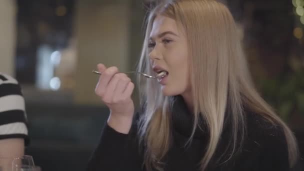 Chica guapa rubia glamour con pestañas falsas comiendo en el restaurante. Señora disfrutando de su comida en la cafetería. Ocio de la mujer joven moderna — Vídeos de Stock