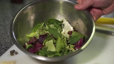 Şef taze lahana yaprakları, kiraz domates ve marul ile lezzetli bir salata hazırlar. Lezzetli bir yemek pişirme kavramı.