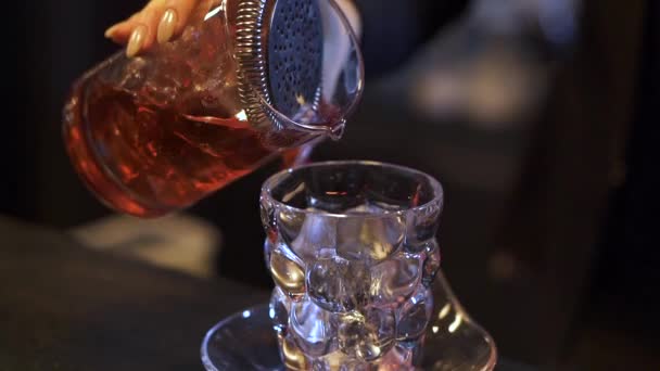 Camarera femenina con hermosa manicura preparando cóctel en el bar. Mano de chica vertiendo alcohol en el vaso. Vida nocturna, estilo de vida poco saludable. Movimiento lento — Vídeo de stock