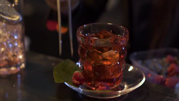 Barman připravuje koktejl v baru. Barman borůvkový a malinový nasadil deska poblíž alkohol sklo. Noční život, nezdravý životní styl. Zpomalený pohyb — Stock video