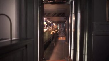 Güzel ve zengin tasarımı modern lüks Restoran barda. Sayaç, geometrik desenli cam duvar bar konforlu sandalyeleri yakınındaki. Kapının arkasından ateş. Kamera hareketleri doğru
