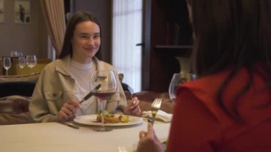 Modern restoranda, birlikte oturan iki pozitif kız arkadaşım. Sohbet konuşmak kız lüks restoranda görüşme. Arkadaşlar toplantı rahat bir yerde toplanmış olur.