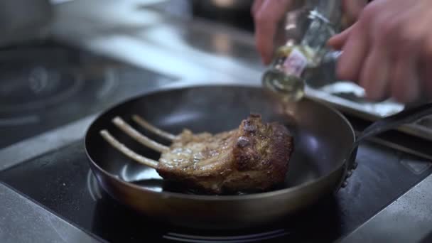 Les mains du cuisinier versant des côtes fraîches savoureuses juste cuites avec l'alcool et met le feu à elle. Cuisinez en préparant des plats de viande appétissants dans un restaurant moderne. Mode de vie sain — Video