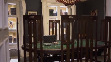 Oyun Masa poker ile yeşil yüzey üzerinde modern casino, yüksek geri sandalyeleri yakınındaki ayakta ayarlayın. Standart iç bekleyen misafirler için rahat yer