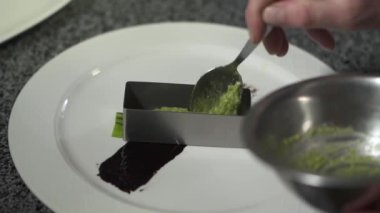 Modern restoranda Şef elleri kaşık ve küçük metal kalıp kullanarak plaka wasabi koyarak kapatın. Yemek hazırlama balık yemi. Ağır çekim