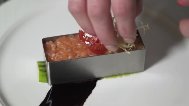 Chef hands decorating minced salmon formed in small metal mold close up in the modern restaurant. Cook preparing fish food. Slow motion — Stock Video