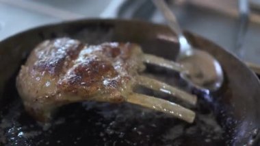 Sulu pirzola var üzerinde dökme Şef el daha sulu ve yumuşak yemeği yapmak için yağ ile tavada kızartma. Modern restoranda lezzetli et gıda hazırlama pişirin. Sağlıklı yaşam tarzı